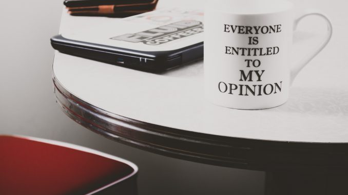Le pouvoir de communication des objets publicitaires Tasse blanche avec inscription posée sur un bureau avec ordinateur