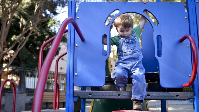 Jeux Petit garçon qui s'amuse dans une aire de jeux pour enfants