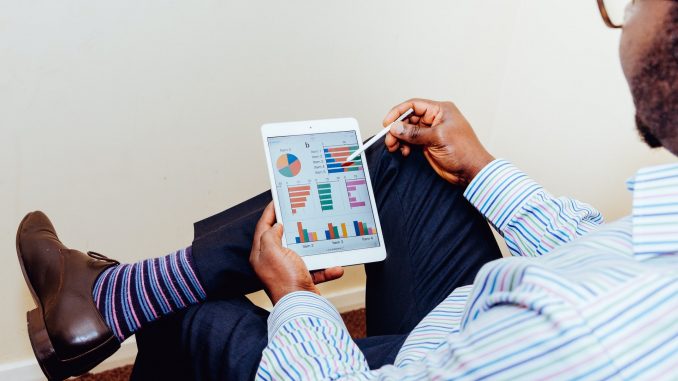 démarche qsste homme analysant des graphiques sur un ipad