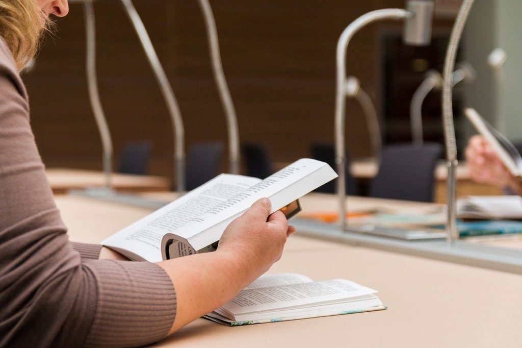 personne qui lit un livre à la bibliothèque