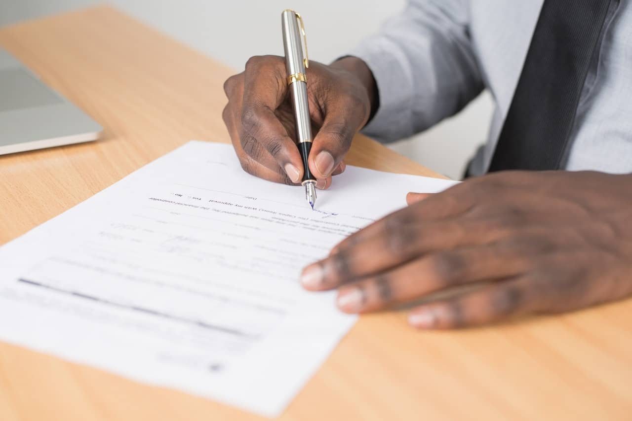 personne en train de signer un contrat