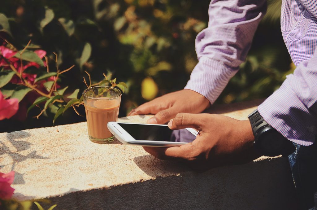 Wi-fi hôtel, homme sur son téléphone portable avec un café